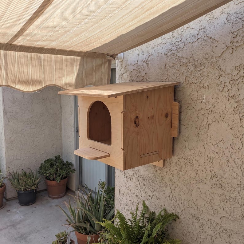 Precision-cut plywood nesting house showing the entry hole detail